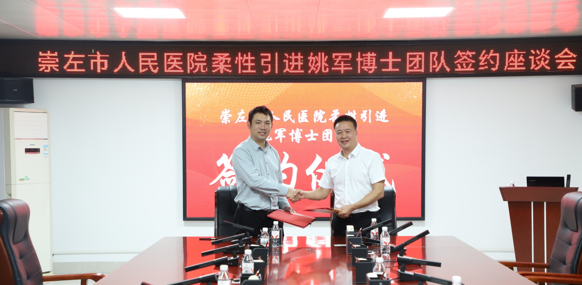 博士团队签约图片,左为姚军博士,右为市人民医院党委书记李晔。
